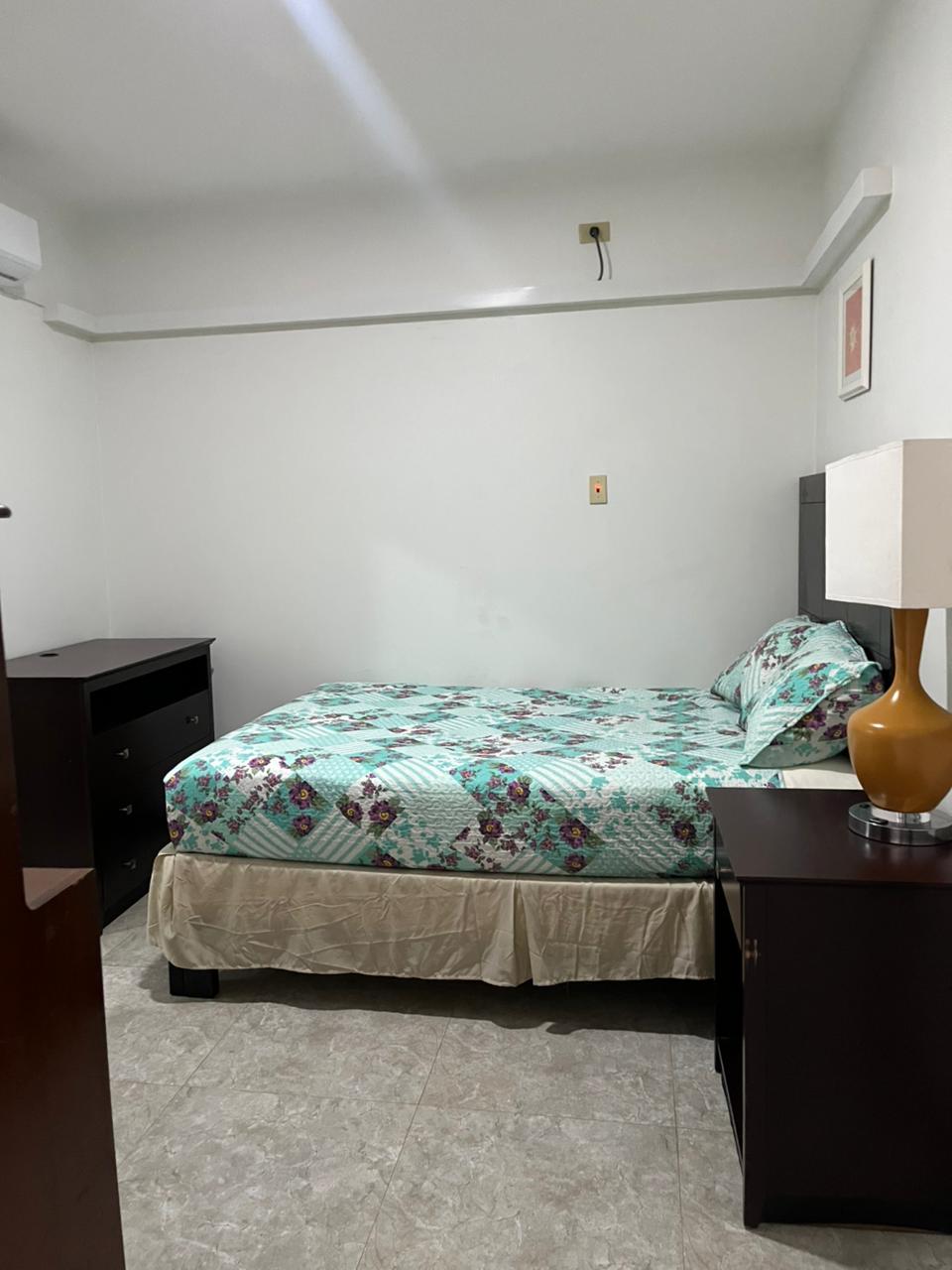 Bedroom with queen bed and dresser