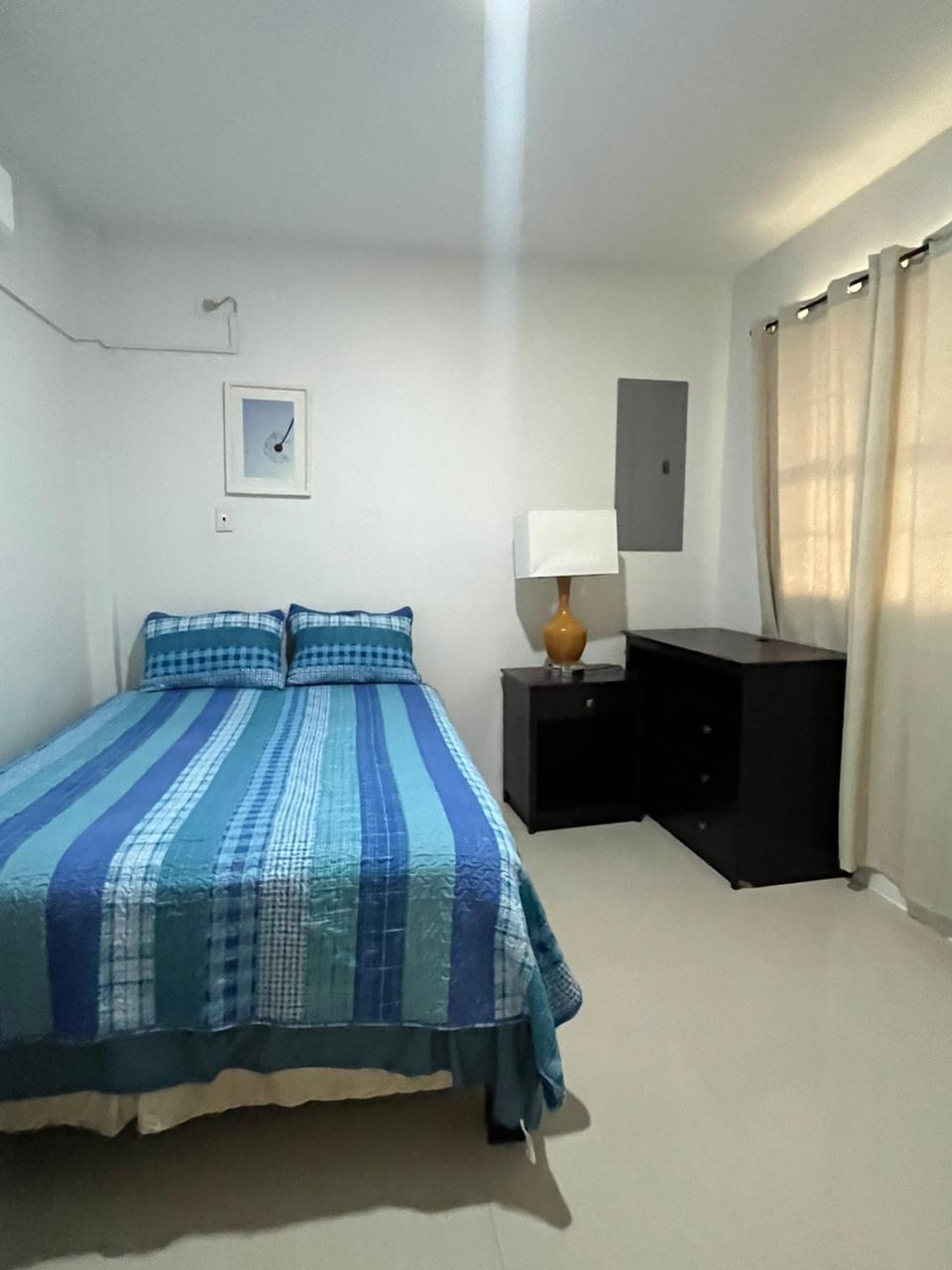 Bedroom with dresser and curtained window