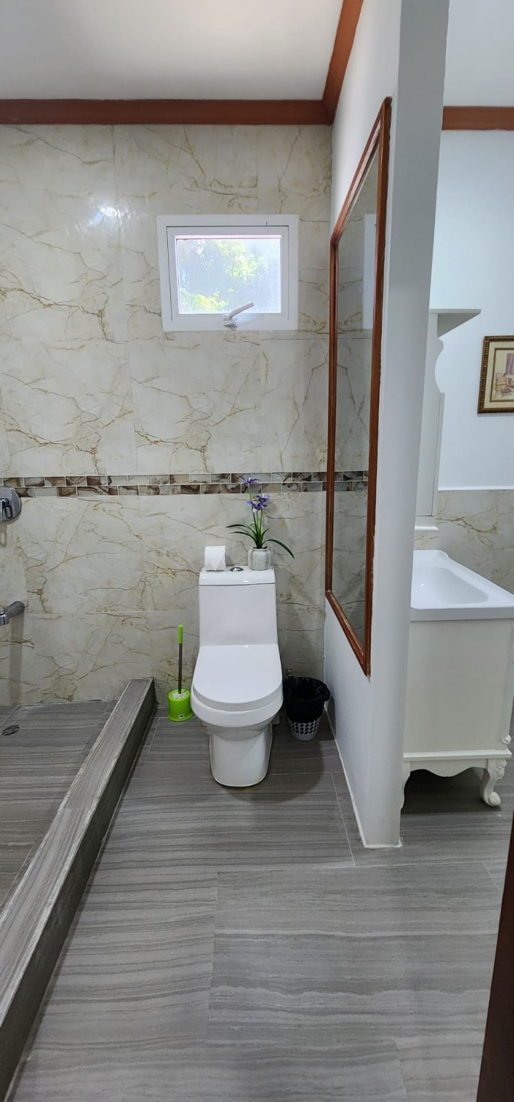 Shared bathroom with marble-finished shower and vanity
